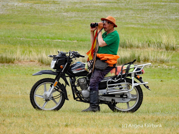 herder on motorcycle with binoculars