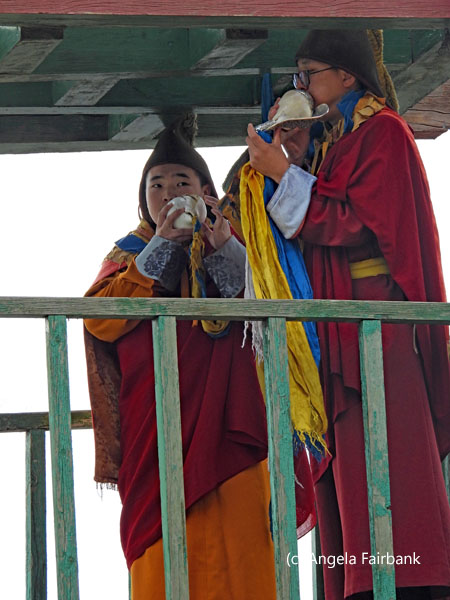 monks blowing conch shells
