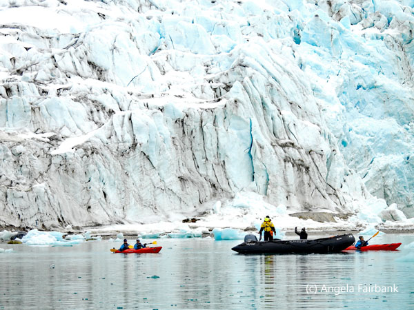 kayaks and zodiac by glacier