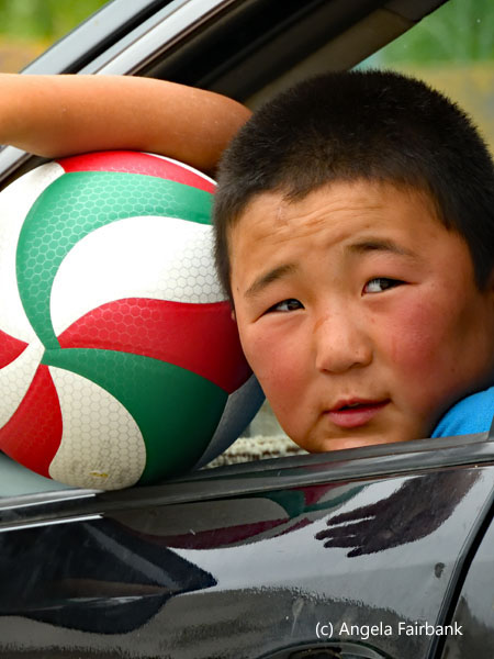 boy in car with ball outside restaurant