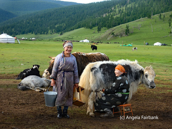 smiling hostess and daugther-in-law with yaks