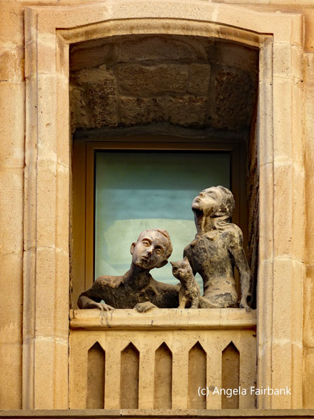 statues of boy and girl on balcony in old town