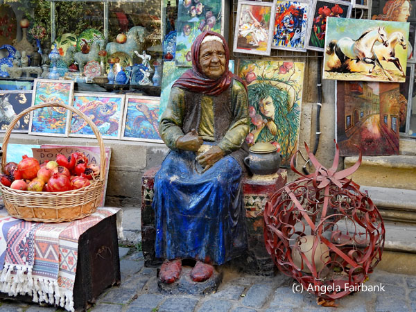 statue of old lady in front of souvenir store in old town