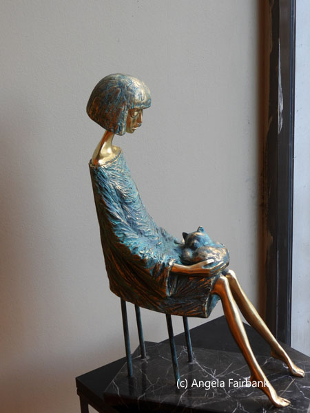 bronze statue of woman sitting with cat