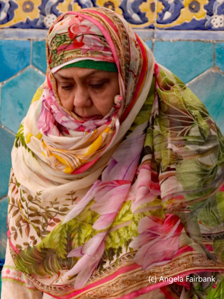 woman in pinks and greens praying
