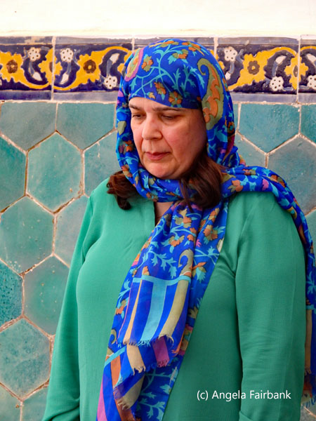 woman in blues and greens praying