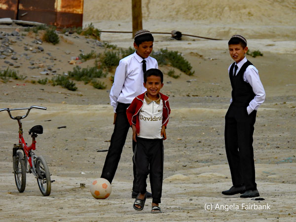 3 boys with a bike and a ball