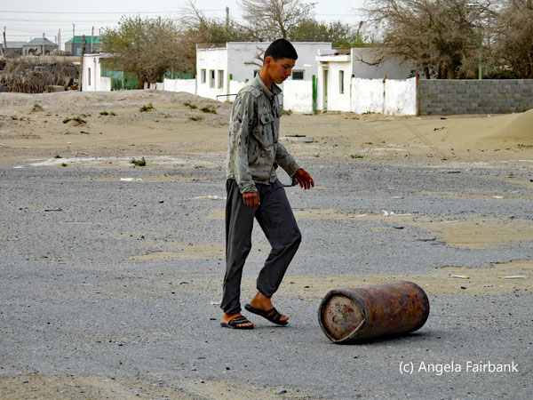 young man kicking a metal cylinder