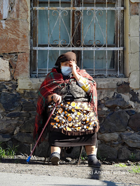old woman seated with stick