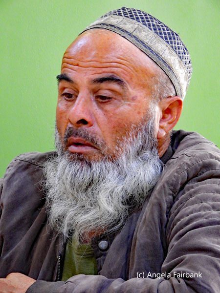 old man with beard and hat in restaurant