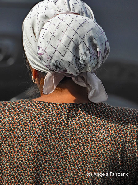 back of woman in white head scarf with hair in a bun