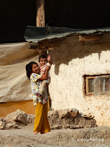 sister and brother in village waving