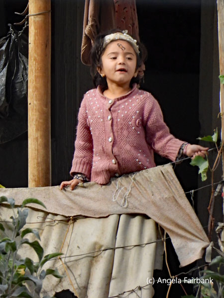 girl in pink sweater at window
