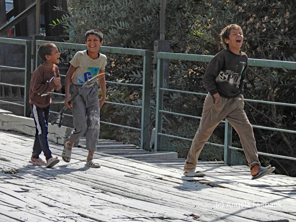 laughing boys walking across Gharibak Bridge