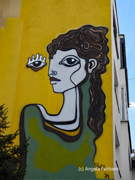 green and yellow mural on side of house