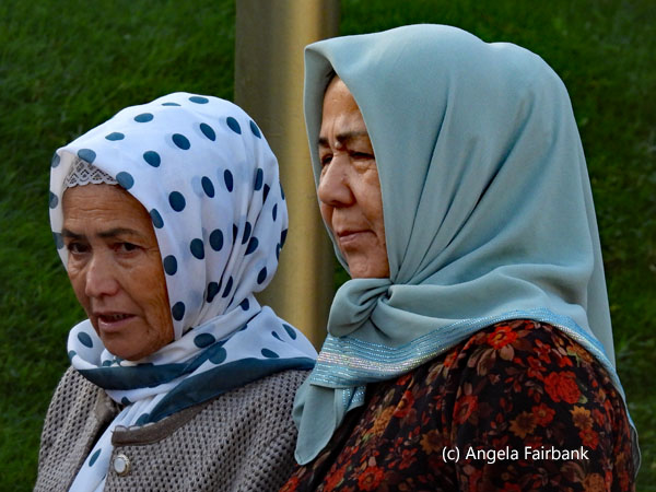 2 elderly ladies in headscarfs facing left