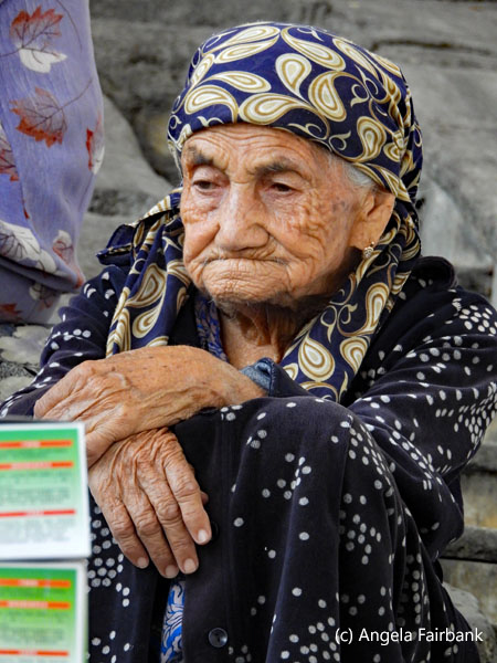 old woman on stairs at market 1