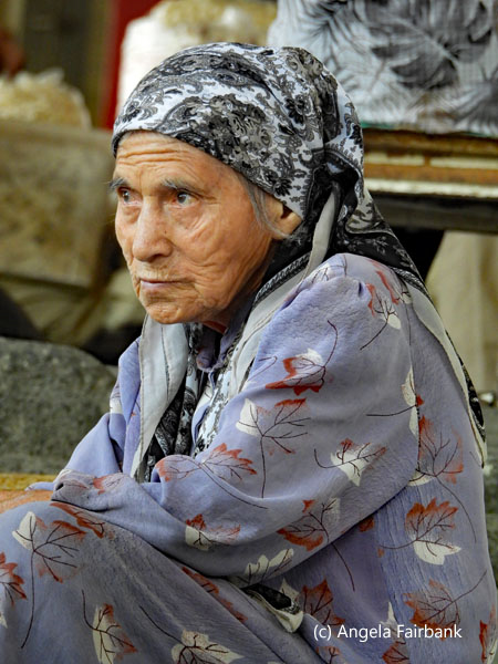 old woman on stairs at market 2