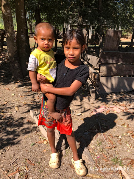 girl carrying her younger brother