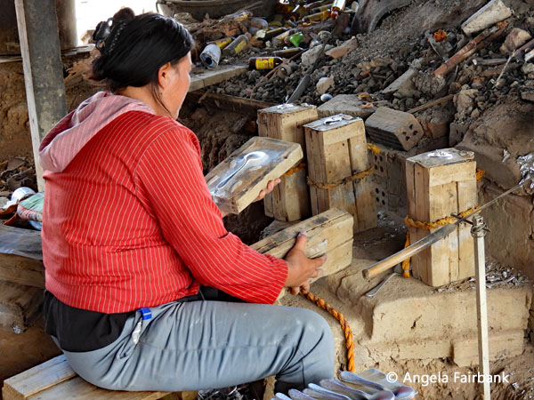 woman making moulds of tin spoons