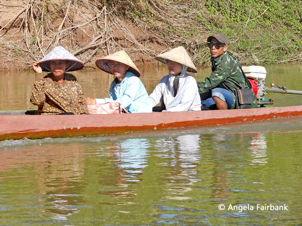 women in conical hats in boat on Mekong