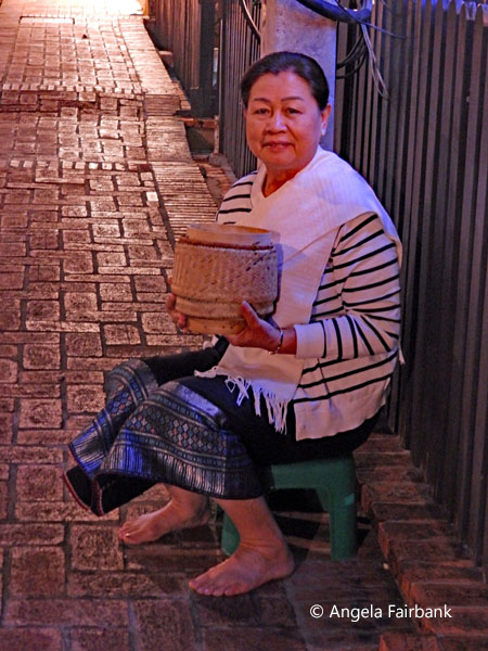 local woman ready to give alms to monks and novices