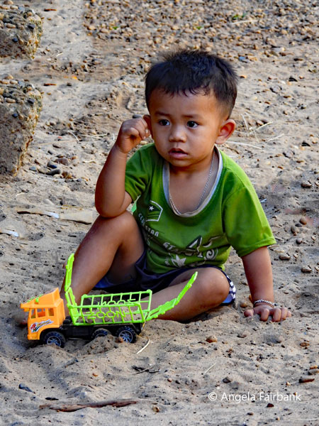 boy with truck in sand