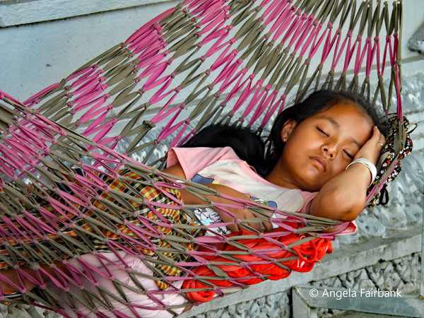 girl sleeping in hammock on street
