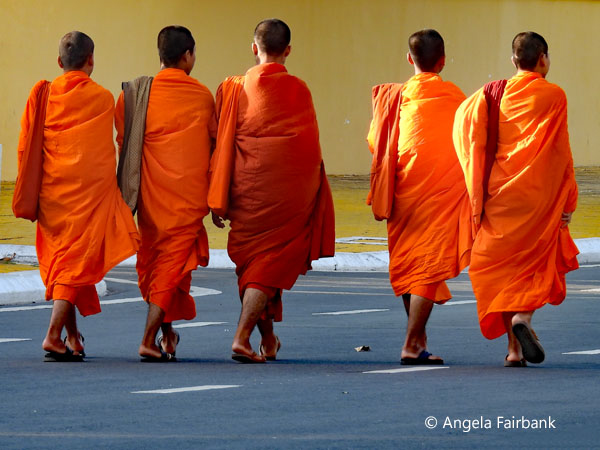 5 monks walking on the street by the royal palace