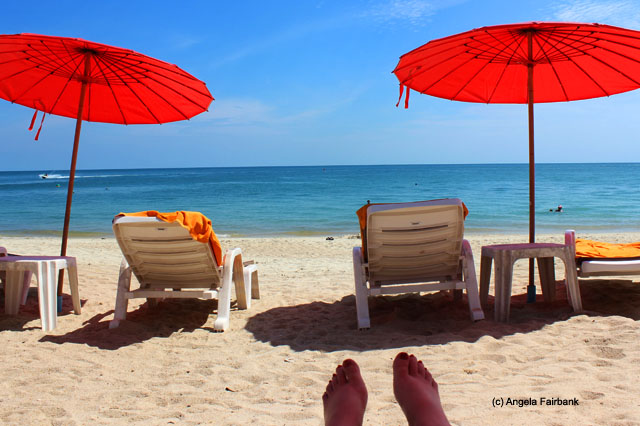 feet, umbrellas and beach chairs