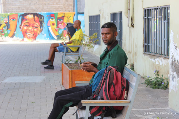 2 men on benches surrounded by mural art
