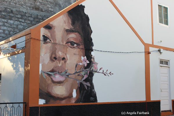 woman with flower on house