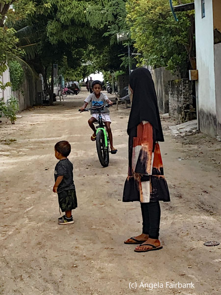 children and boy on bike