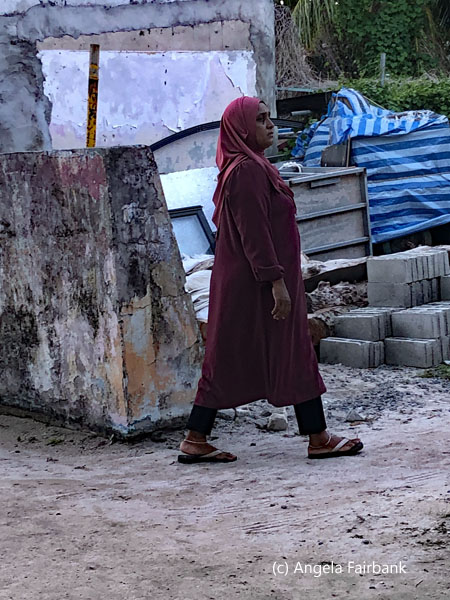 woman in front of junk yard