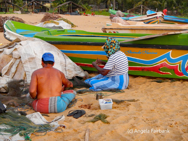 man and woman repairing nets