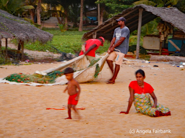 men pulling nets with woman and child