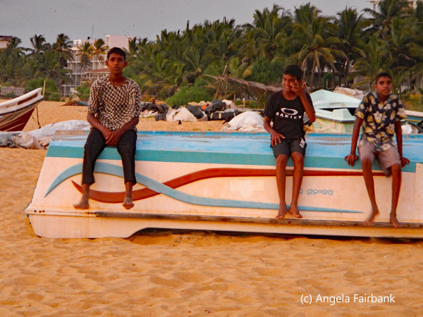 3 boys sitting on boat