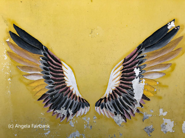 wings art on yellow wall