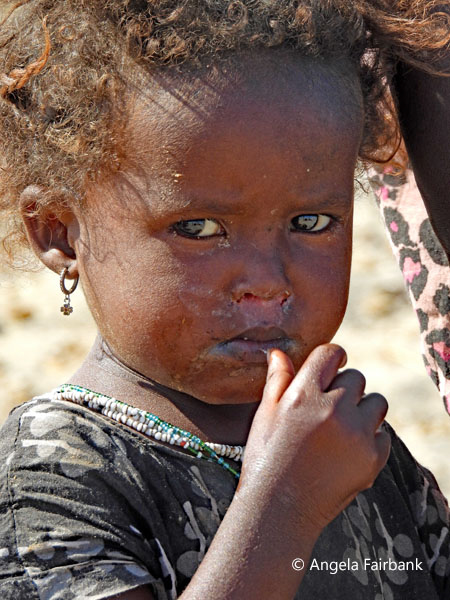 Afar girl with hand to mouth