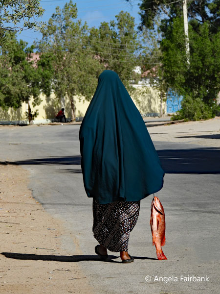 woman walking with fish 