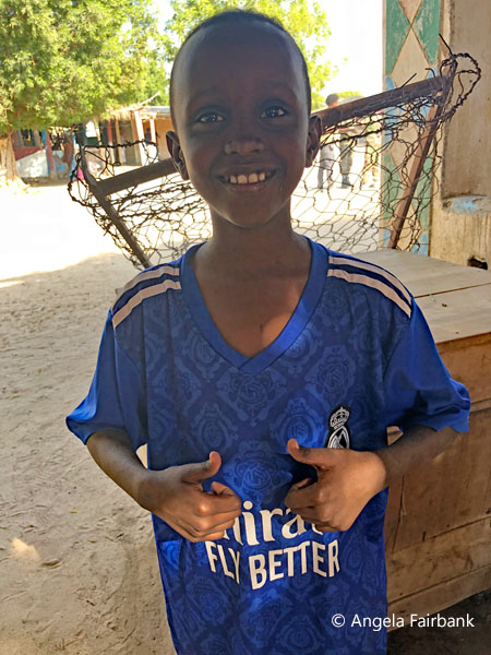 boy standing in Emirates shirt