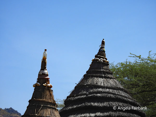 hut roofs topped by plastic water bottles