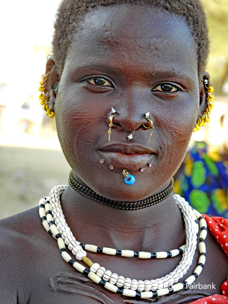 young woman with multiple earrings at market