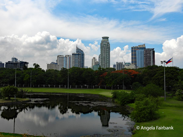 manila highrises reflected in park pond