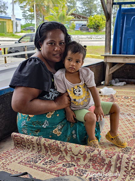 woman and child in truck bed outside post office