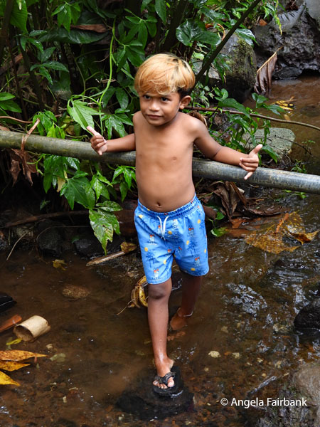 blond=haired boy in stream contianing eel