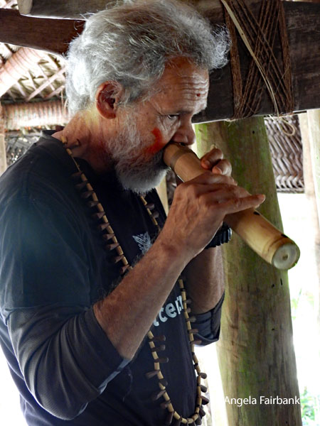 man playing nose flute