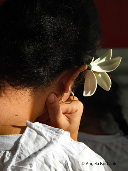 girl on ferry with flower in her right ear