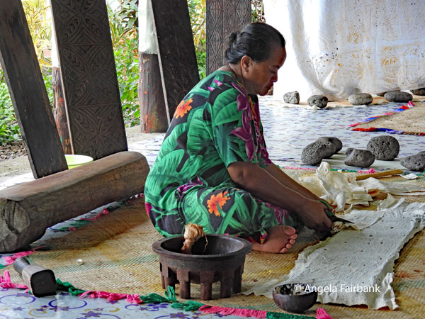 woman demonstrating the making of Siapo designs