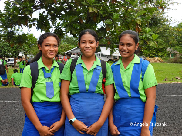 three school girls opposite Siapo making house